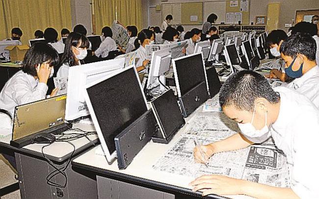 山陰中央新報に目を通す生徒＝大田市仁摩町仁万、大田西中学校