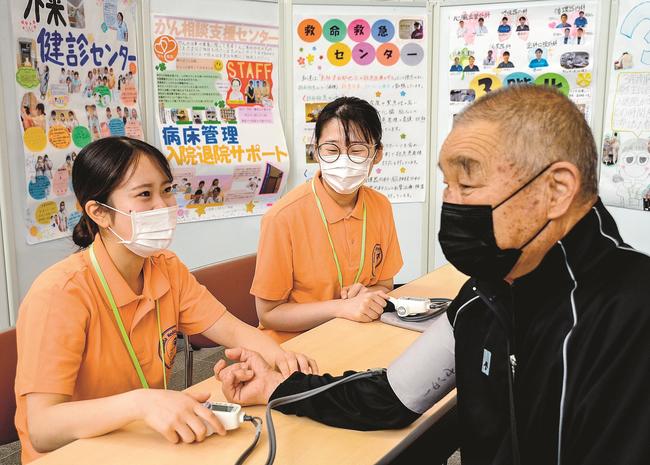 外来利用者の血圧を測定する看護師（左）＝浜田市浅井町、浜田医療センター