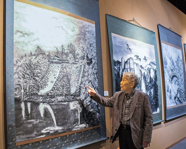 松江城を題材にした作品「夜桜」を紹介する西村俊雄さん＝出雲市天神町、今岡美術館