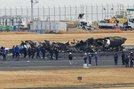 焼け焦げた海上保安庁の航空機の周辺に集まる警視庁の捜査員や東京消防庁の隊員ら＝３日午前１１時１２分、羽田空港