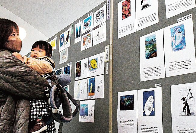 絵はがき作品に見入る来館者＝浜田市・江津市、水族館アクアス
