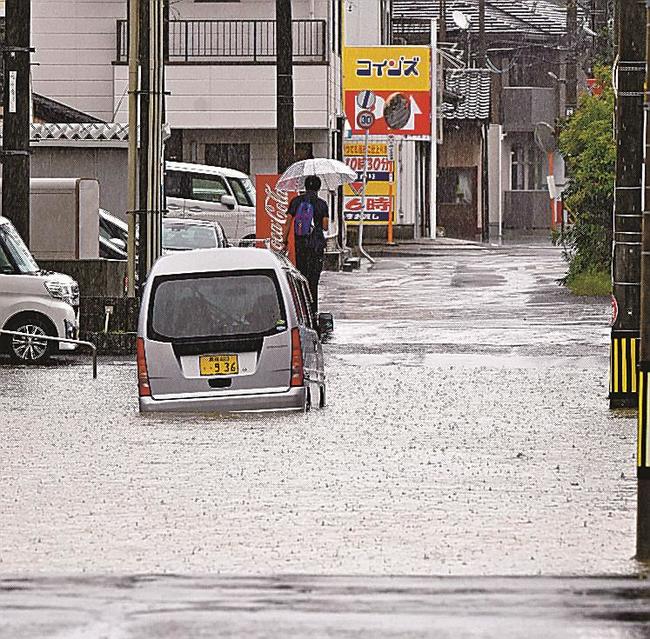 冠水した道路で立ち往生する軽自動車＝５日午前９時１１分、松江市黒田町