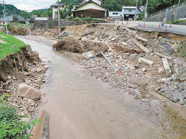 道路がえぐられ、管がむき出しの状態となっている雲南市三刀屋町多久和地区。１６日現在も断水が続く