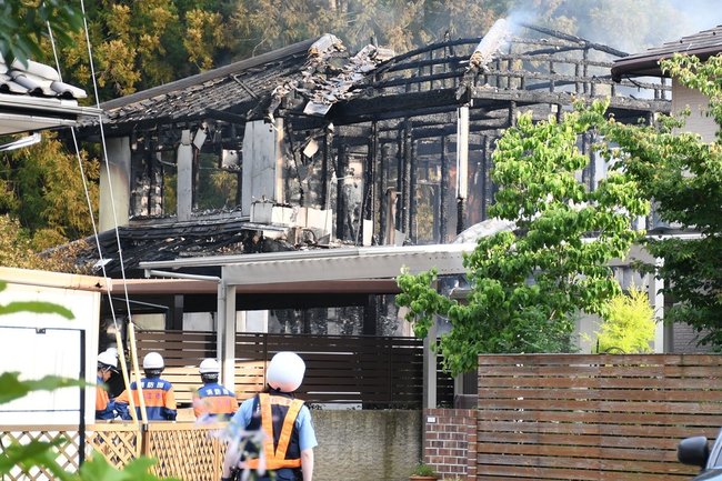 現場を確認する消防団や警察関係者＝５日午前６時２５分、松江市上東川津町