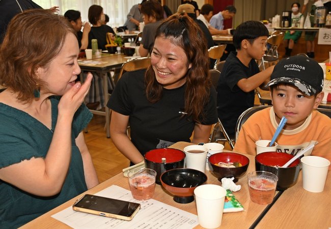 来場者に笑顔で声を掛ける稲田有咲さん（中央）＝益田市遠田町、安田公民館