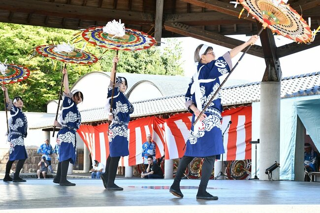 後ろ手で傘を操る峰延東傘踊り保存会のメンバー＝鳥取市国府町町屋、因幡万葉歴史館