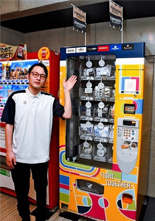 バスケットボール用品の自動販売機を紹介する社員＝松江市学園南１丁目、松江市総合体育館