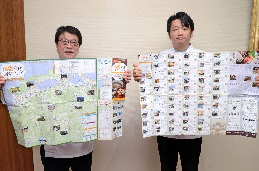 ガイドマップを広げる玉木暢会長(右)と岡敏和事務局長=出雲市今市町、市役所