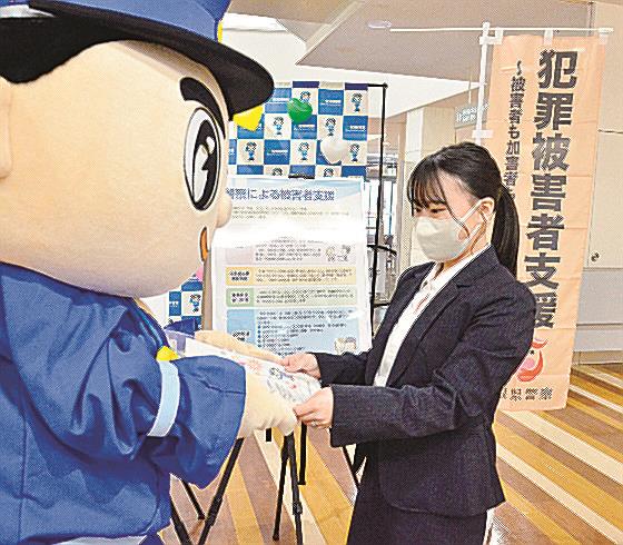 島根県警のマスコットキャラクター「みこぴーくん」から犯罪被害者支援のチラシを受け取る市民＝２０２２年１１月、松江市内
