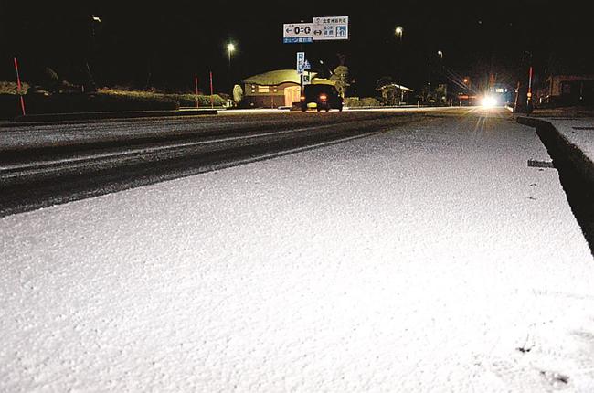 うっすらと雪が積もった国道５４号を通過する車両＝１７日午後８時２３分、島根県飯南町花栗