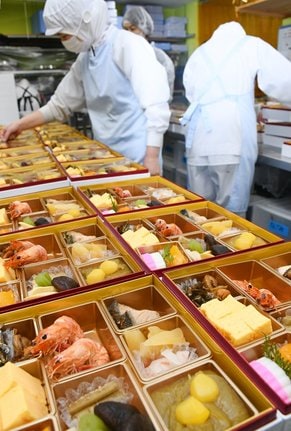 重箱の料理を整え、出荷の準備をする従業員＝出雲市姫原４丁目、おいしさ工房　ふるかわ