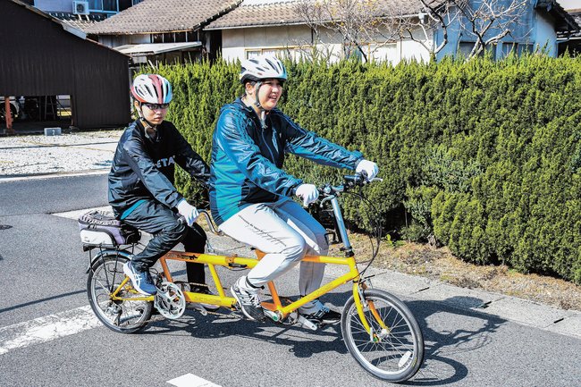 練習でタンデム自転車に乗る新宮愛菜さん（左）と榎本加奈子さん＝出雲市姫原町