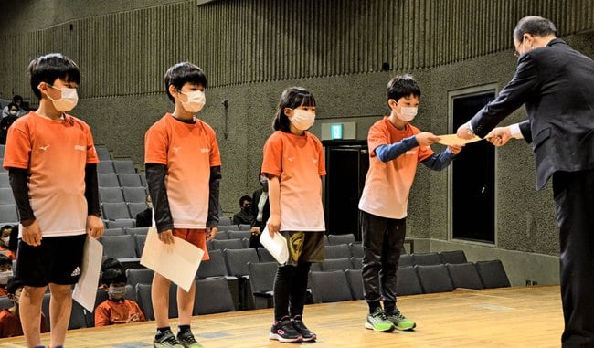 県競技力向上対策本部長の松尾紳次副知事(右端)から認定証を受ける子どもたち=松江市殿町、県民会館