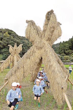 ヨズクハデの丸太の間を通り抜けて遊ぶ園児＝益田市本俣賀町