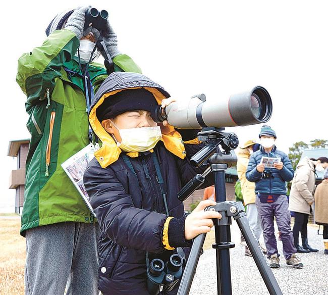 双眼鏡や望遠鏡で鳥の姿を観察する参加者＝出雲市園町、宍道湖グリーンパーク