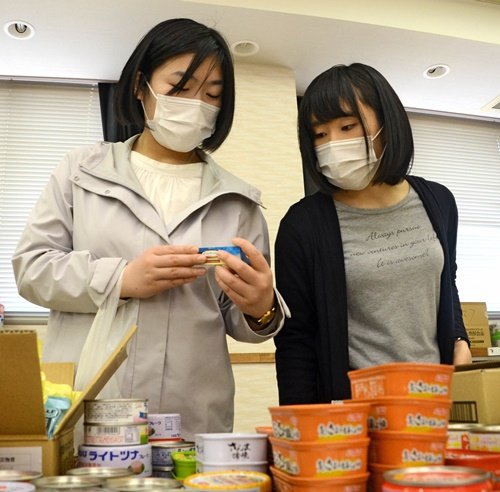 食料品の袋詰め作業をする宮迫瑞穂さん（左）と三島亜美さん＝出雲市今市町、市社会福祉協議会