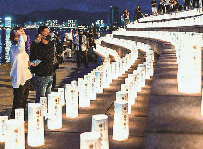 幻想的なあんどんの世界を見入る市民＝２６日夕、松江市袖師町