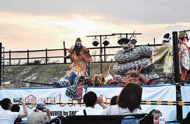 プロレスのリングを舞台に大蛇を舞う石見神楽波子社中＝江津市波子町、波子海水浴場