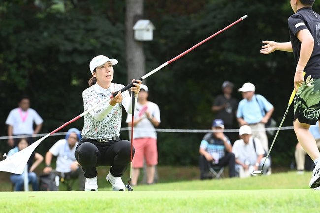 ９番でピンを渡す李知姫＝2日、大山平原ゴルフクラブ