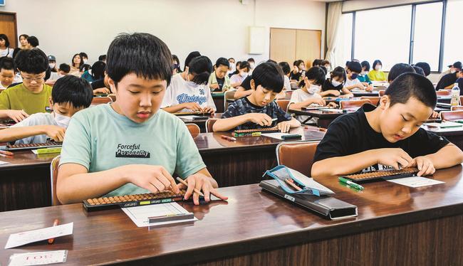 真剣な表情でそろばんをはじく出場者＝出雲市塩冶有原町２丁目、市民会館