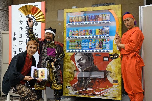 御将印が買える自動販売機をＰＲする関係者＝松江市末次本町、カラコロ広場