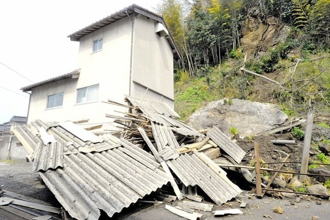 島根県西部地震で崩れた巨岩を受けて壊れた倉庫＝２０１８年４月、大田市内