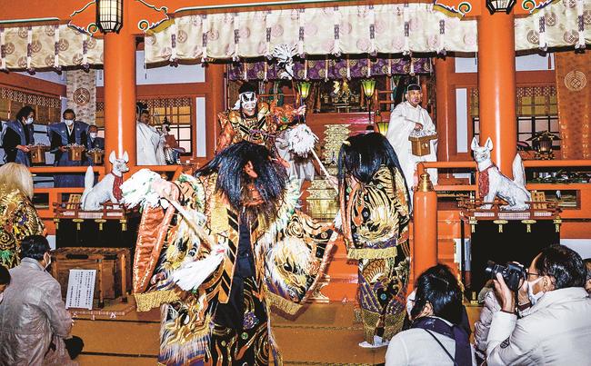 石見神楽の鬼に向かって豆をまく神職たち＝島根県津和野町後田、太皷谷稲成神社
