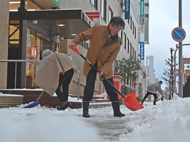 雪かきをする人たち=22日午前7時24分、鳥取市東品治町