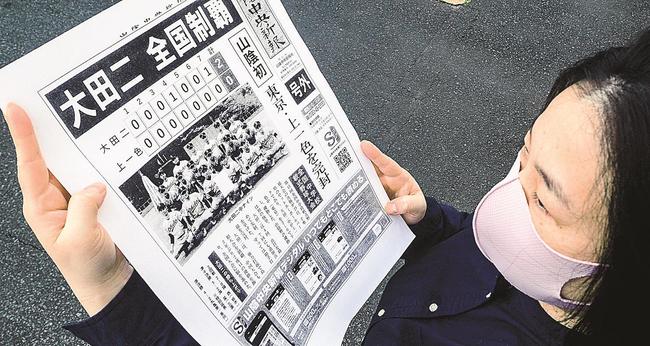 山陰中央新報社の号外に見入る市民＝大田市大田町