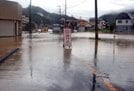 大雨の影響で冠水し、通行止めとなった道路＝１３日午前１１時２３分、鳥取市福部町