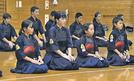 大社スポーツ少年団のメンバーらと並んで前島信人監督の話を聞く槙原栞那さん（前列左から２人目）ら＝出雲市大社町杵築南、大社小学校体育館