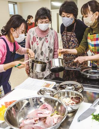 参加者に調理加減など伝えるダム・ゴック・クァンさん(左)=境港市昭和町、境港おさかなパーク