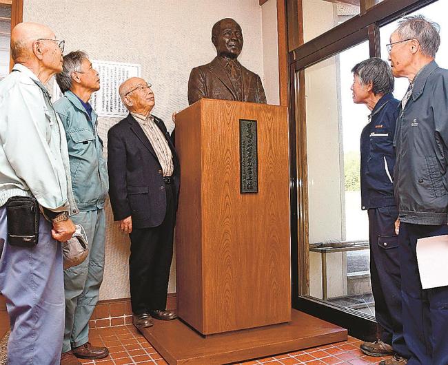 日高忠男の胸像を見つめる西鱒渕自治会の人たち＝島根県邑南町鱒渕、西鱒渕会館、２０２２年１０月、資料