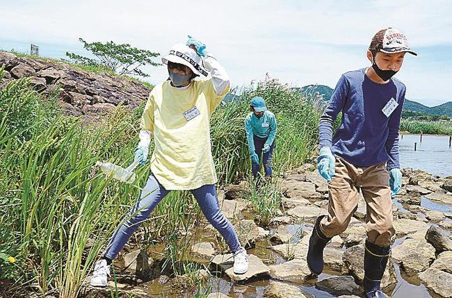 宍道湖岸で漂着物を採取する探偵団の小中学生＝出雲市園町