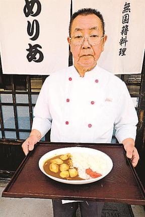 里芋カレーを手にする椿福義さん＝島根県津和野町後田