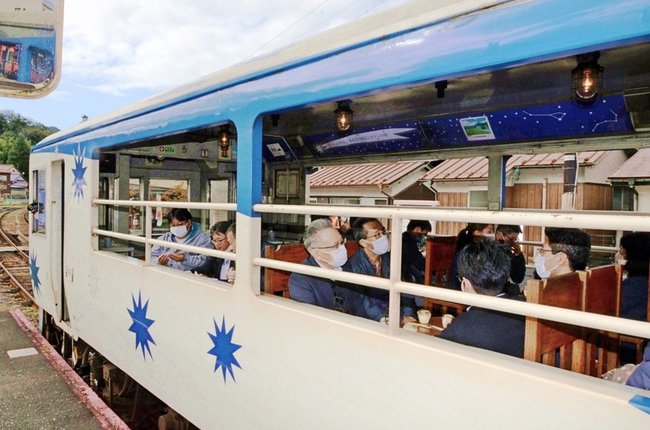 発車を前におろち号の車内で談笑する会員ら＝雲南市木次町里方、ＪＲ木次駅