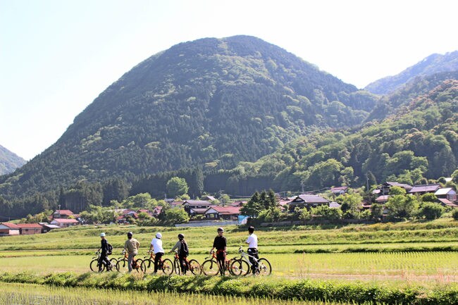 高峯山を見上げながらサイクリングを楽しむツアー参加者＝島根県津和野町高峯