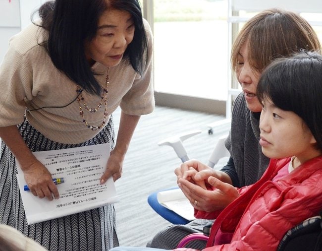 守本早智子さん（左）に教わりながら指筆談を練習する参加者＝安来市亀島町、さんそ学習館ケイオス
