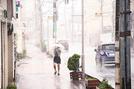 強風にあおられる傘を持つ歩行者＝松江市朝日町