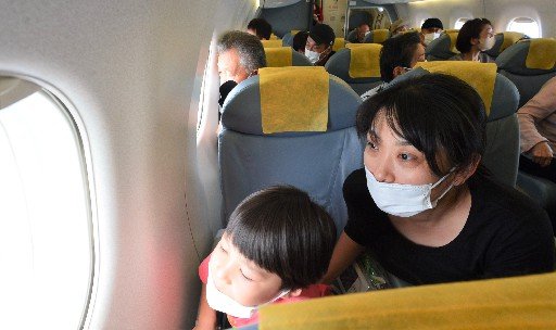 機内からの眺望を楽しむ家族＝日本海上空