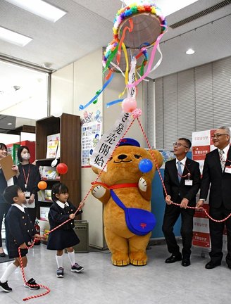 年賀はがきの販売を記念し、くす玉を割る園児＝松江市東朝日町、松江中央郵便局
