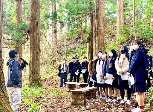 「２００年の森遊歩道」で、森林や林業の役割を聞く倉吉東高校の修学旅行生＝鳥取県日南町阿毘縁（町提供）