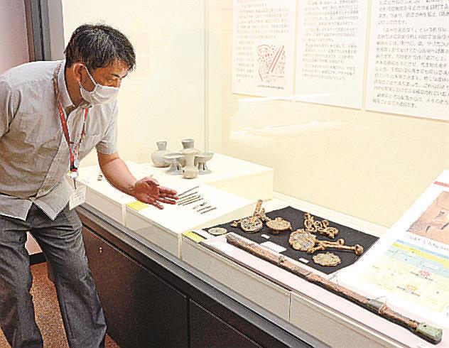 国富中村古墳で見つかった馬具や刀について説明する坂本豊治主任＝出雲市大津町、出雲弥生の森博物館