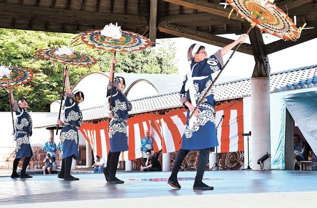 後ろ手で傘を操る峰延東傘踊り保存会のメンバー＝鳥取市国府町町屋、因幡万葉歴史館