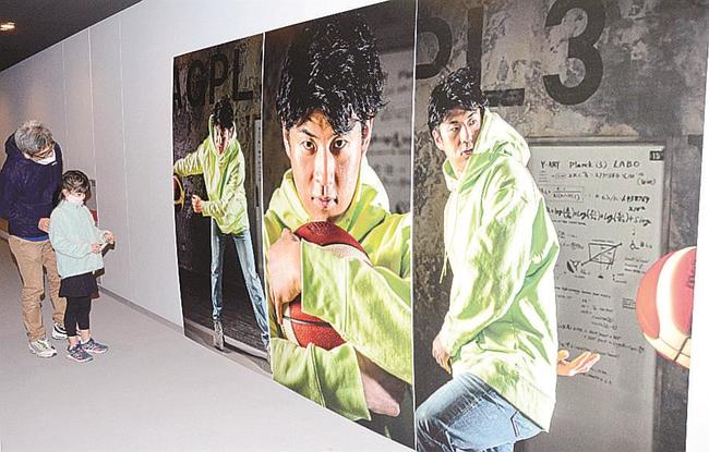 安藤誓哉選手の特大写真パネルを見る来場者