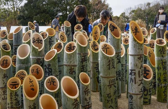阪神・淡路大震災の追悼行事に向け、「絆」や「祈」などの文字が書き入れられた竹灯籠＝６日、神戸市北区の「あいな里山公園」