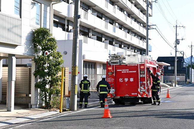 消火活動に当たる消防隊員ら＝１９日午前９時５５分ごろ、松江市大輪町、県営大輪団地１号棟