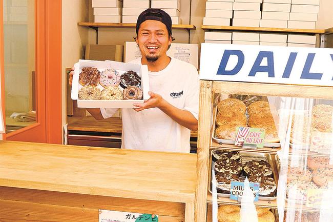 店頭に立ち、来店客を笑顔で出迎える森口祐太郎さん＝島根県隠岐の島町西町、ベイクハウス　ベンチ