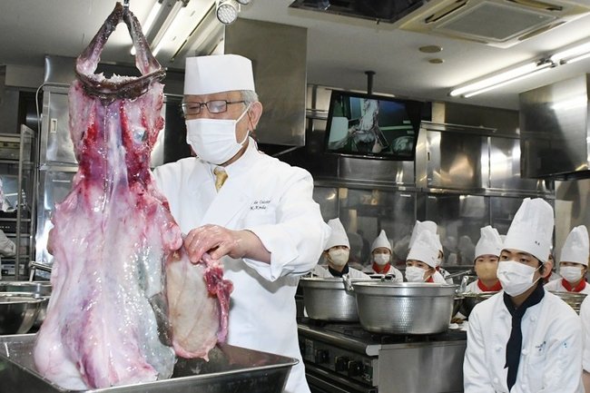 アンコウのつるし切りに注目する学生たち＝松江市伊勢宮町、松江栄養調理製菓専門学校