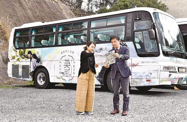 ラッピングバスの前で打ち合わせする澄田健司社長（右）たち＝浜田市上府町、浜田交通